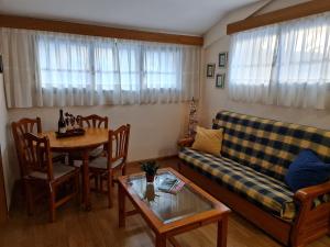 a living room with a couch and a table at Amanecer Camp d Aljub in Candanchú