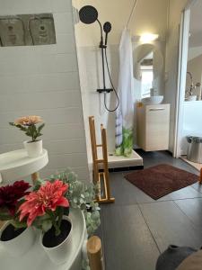 a bathroom with a sink and a shower with flowers at HYPER CENTRE - 2 STUDIOS - 2min PLACE KLEBER in Strasbourg +10 photos