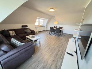 a living room with a couch and a table at Ferienwohnung Blinkfüer in Hinte