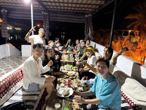 阿斯旺Seko Kato Nile View Hostel的一群人围坐在桌旁吃饭