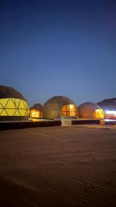 アカバにあるWadi Rum Marcanã campの夜のビーチに並ぶドーム