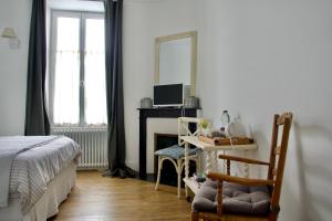 une chambre avec un bureau avec un ordinateur et un miroir dans l'établissement La Joséphine, à Cosne Cours sur Loire