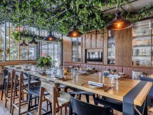 a long table in a restaurant with plants at Mercure Katowice Centrum in Katowice