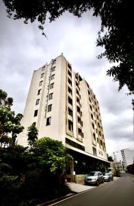 a white building with cars parked in front of it at Le Basilic Hotel Apartment & Spa in Addis Ababa