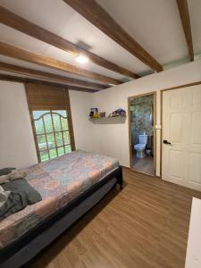 a bedroom with a bed and a bathroom with a toilet at Espectacular Casa-Bonobohouse al lado del rio con reserva natural in Acacías