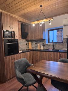 a kitchen with a wooden table and two chairs at Pelion Experience in Zagora