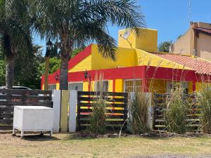 a colorful house with a fence in front of it at Rancho la Pradera in Deán Funes