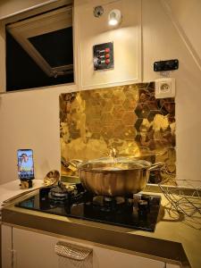 a pot on top of a stove in a kitchen at Kawaida - Hébergement insolite - Yaliyo in Saint-Pierre