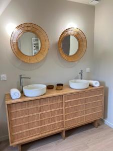 a bathroom with two sinks and two mirrors at La longère de Sarlat in Sarlat-la-Canéda