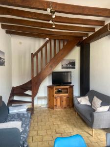 a living room with a staircase and a couch at Maison au carrefour des terroirs in Pouançay