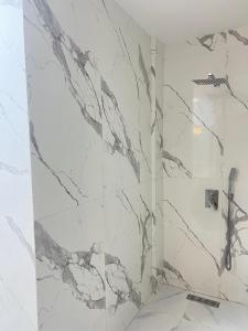 a bathroom with a shower with marble walls at Real appartement in El Jadida +3 photos