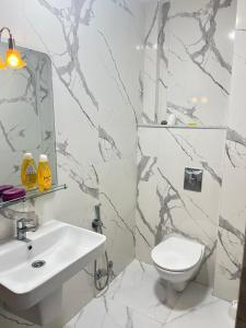a white bathroom with a sink and a toilet at Real appartement in El Jadida