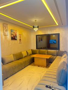 a living room with a couch and a table at Real appartement in El Jadida