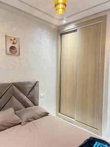 a bedroom with a bed with a large window at Real appartement in El Jadida