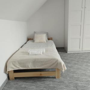 a white bedroom with a bed with two towels on it at Agroturystyka Relax na Kaszubach in Żuromino +26 photos