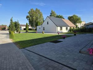 a driveway with a white house in the background at Agroturystyka Relax na Kaszubach in Żuromino