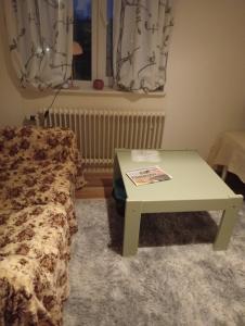 een woonkamer met een tafel en een bed bij B&Bestrada in Vaggeryd