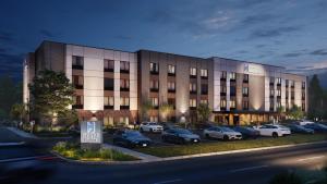a building with cars parked in a parking lot at Hyatt Studios Huntsville in Huntsville