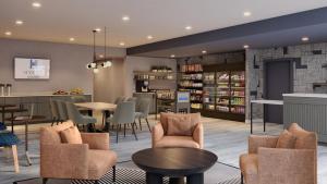 a waiting room with tables and chairs at Hyatt Studios Huntsville in Huntsville