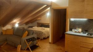 a living room with a couch and a bed at CAMPO BASE CADORE MONOLOCALE MANSARDA con park auto e garage moto in Valle di Cadore