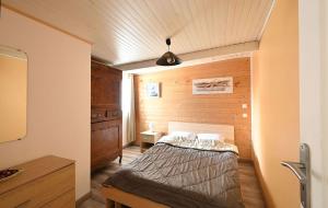a bedroom with a bed and a wooden wall at La venelle des Ormeaux in Les Moulins de la Boire