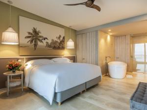 Un dormitorio con una cama grande y una bañera. en Sofitel Barú Cartagena, en Cartagena de Indias