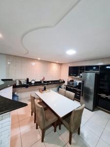 a large kitchen with a white table and chairs at Casa completa Petrolina-PE in Petrolina