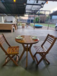una mesa de madera y 2 sillas junto a una mesa y sillas en Suite privativo cafe hidro, en São José do Rio Preto