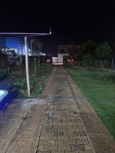 Un camino adoquinado por la noche en un patio. en Suite privativo cafe hidro, en São José do Rio Preto