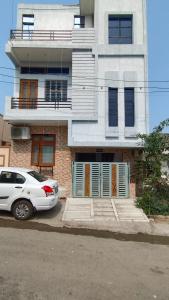 une voiture blanche garée devant un immeuble dans l'établissement Gokul Niwas Home Stay, à Udaipur