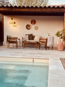 a pool in front of a house with chairs and a couch at Chez Isa et Bruno chambres in Eymet