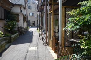 eine Gasse mit Fahrrädern neben einem Gebäude in der Unterkunft Ayaka House Hirai in Tokio
