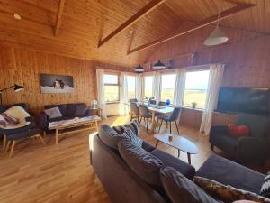 a living room with a couch and a table at Brimilsvellir Cottage in Snæfellsbær