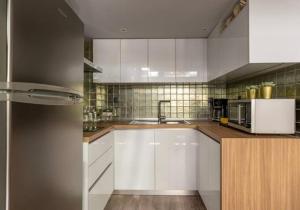 a kitchen with white cabinets and a sink at CITY Loft Lux in Thessaloniki