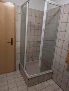 a shower with a glass door in a bathroom at Ferienwohnung Lydia in Olpe +9 photos