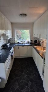 a white kitchen with a sink and a window at Lovely Home In Sauda With Wifi in Sauda