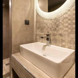 a bathroom with a white sink and a mirror at CITY Loft Lux in Thessaloniki
