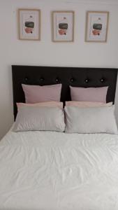 ein Bett mit weißen Laken und rosa Kissen in der Unterkunft NEMARA Self Catering Lodge in Polokwane