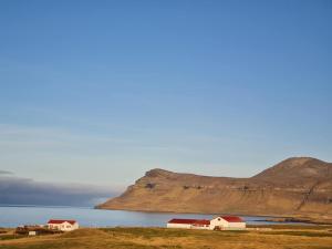 a group of houses on the shore of a body of water at Brimilsvellir Cottage in Snæfellsbær