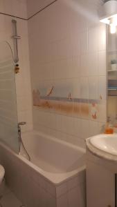 a bathroom with a bath tub and a sink at Manoir du Casino in Cabourg