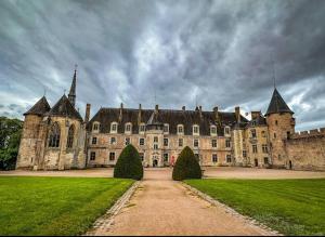un gran castillo con un césped verde delante de él en Studio Confort à Lapalisse, en Lapalisse