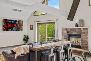 a living room with a fireplace and a table and chairs at Hot Tub and Community Beach Albrightsville Home! in Albrightsville