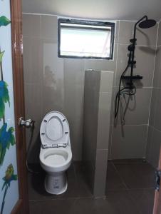 a small bathroom with a toilet and a window at สวนไร่รุ่งอรุณ Suan Rai Rungarun in Ban Na Pa Paek