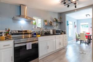 cocina con armarios blancos y fogones negros en Cultural Heritage Award winning home - Ideal for Holiday Stays & Lake Walks, en Austin