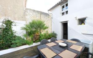 a patio with a table and chairs and a building at Villa des Ormeaux in Les Moulins de la Boire
