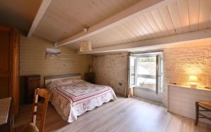 a bedroom with a bed in a room with a window at Villa des Ormeaux in Les Moulins de la Boire