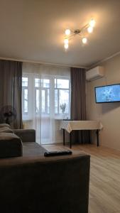 a living room with a bed and a flat screen tv at Apartment near city center on Peremohy Avenue 46 in Chernihiv
