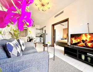 Una sala de estar con un sofá y una chimenea. en Comfy Apt, Rooftop Lounge, Pool, en Ensanche Quisqueya