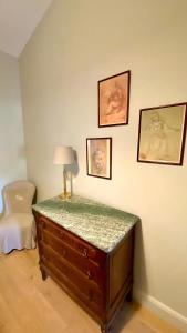 Cette chambre comprend une commode avec une lampe et une chaise. dans l'établissement Château de Jouques, à Gémenos