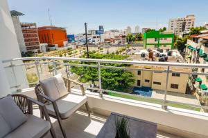 a balcony with chairs and a view of a city at Spacious, 3BD City Center Apt in La Julia